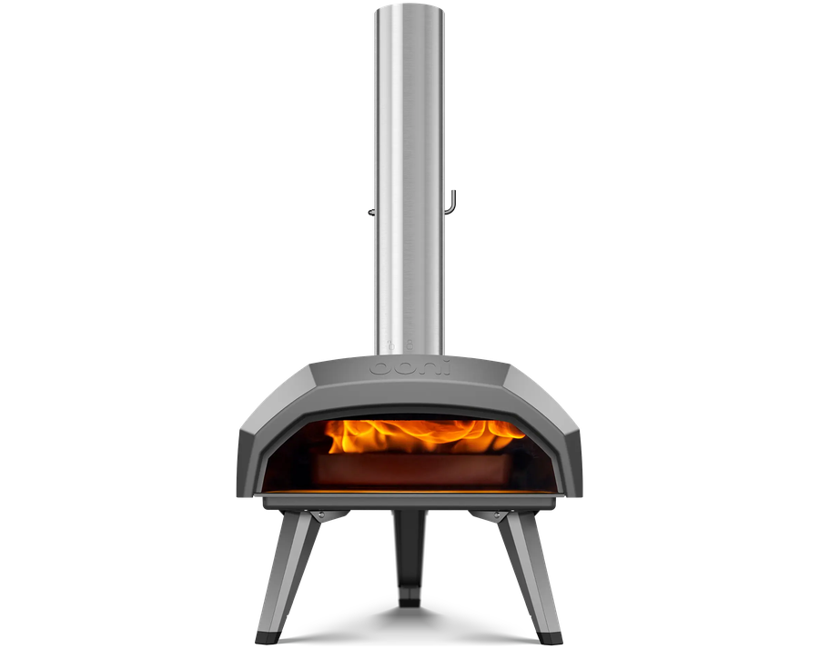 An Ooni pizza oven, its chimney rising from a steel wedge of a body, with fire glowing in the mouth.